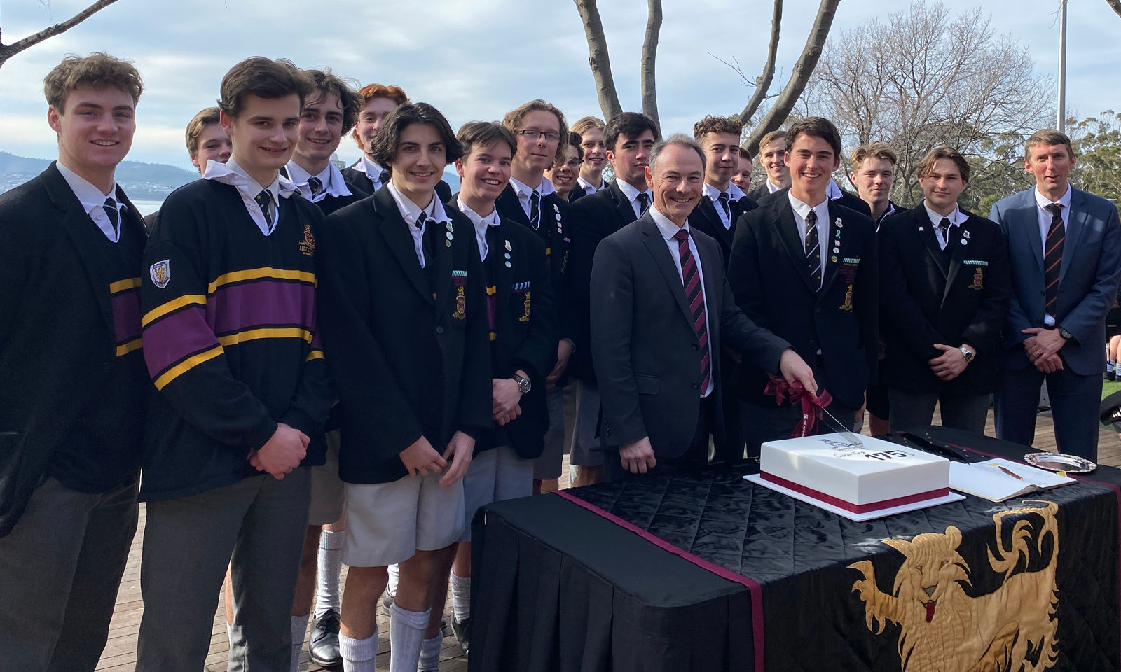 Dr Rob McEwan (Headmaster) cutting anniversary cake with Prefects.